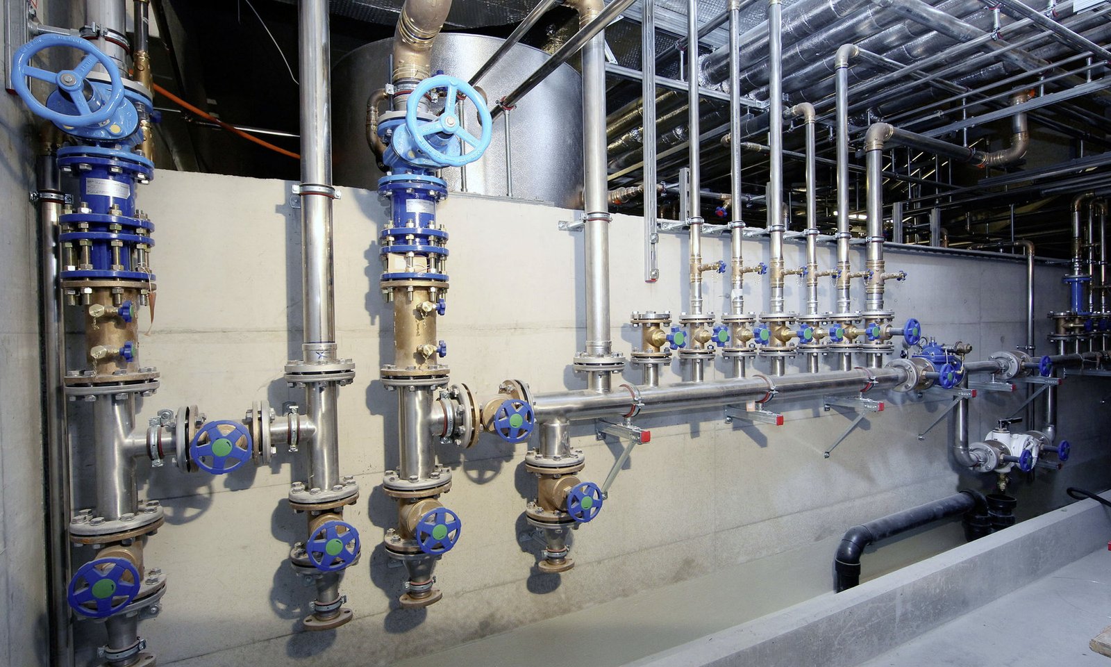 Edelstahlverteiler mit Armaturen und Leitungen einer Sanitärinstallation